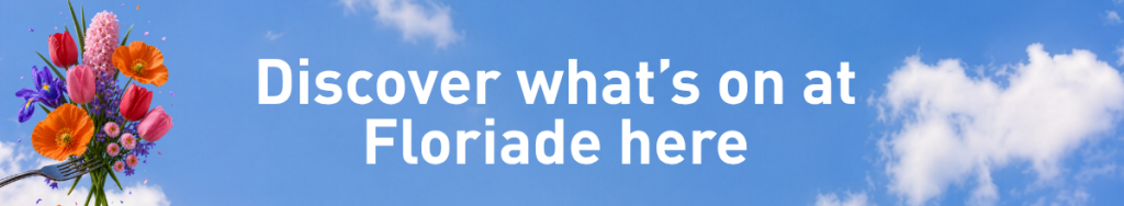 A banner with the text 'discover what's on at Floriade here' withh a bouquet of colourful spring flowers, is arranged on a fork against a bright blue sky with soft white clouds