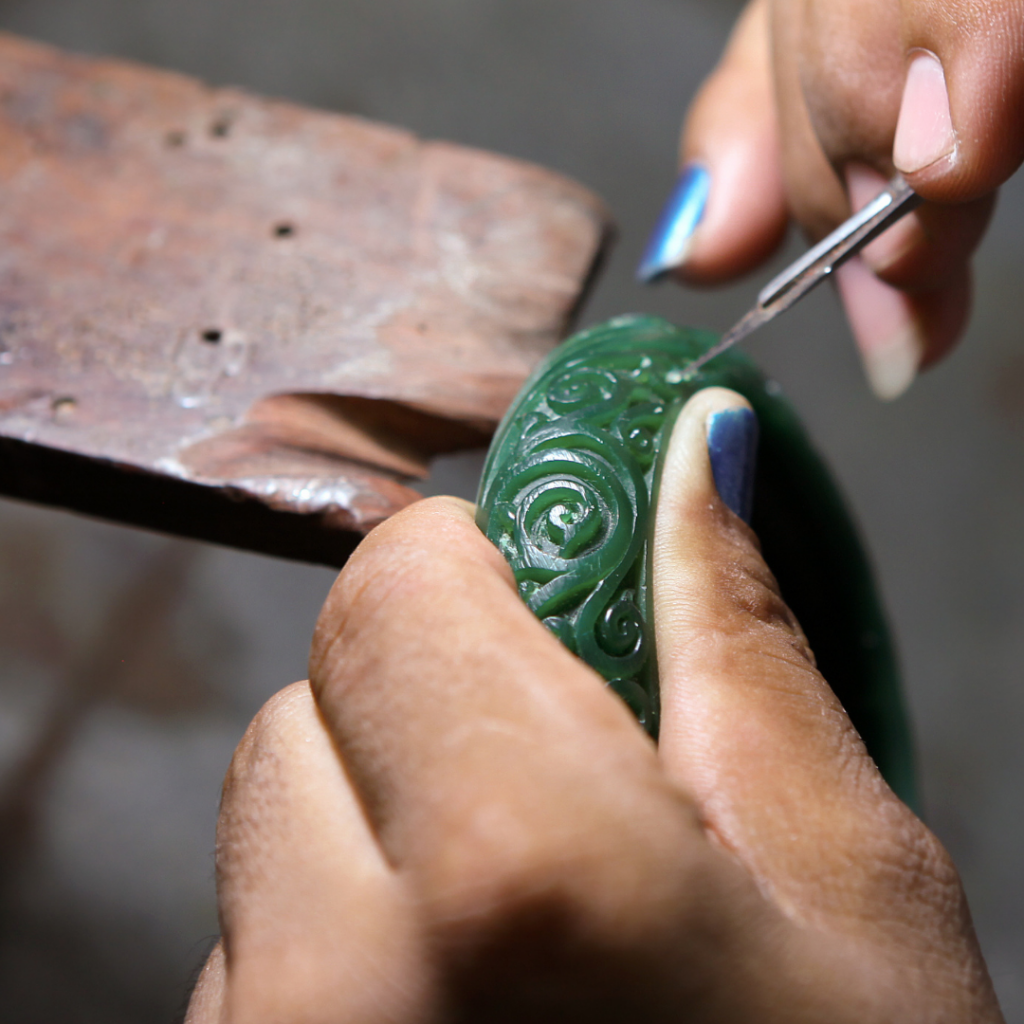 hands holding wax and creating a green sculpture out of a mould